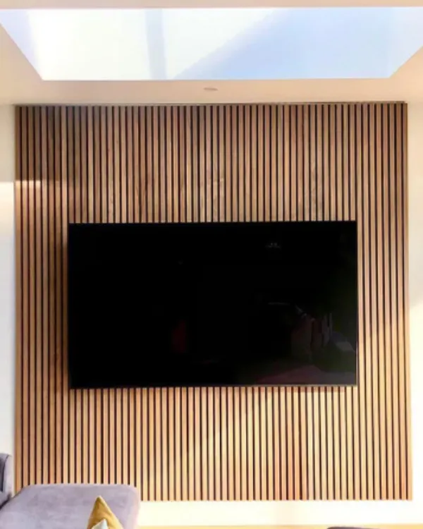 TV wall-mounted on decorative wall panels in London home.