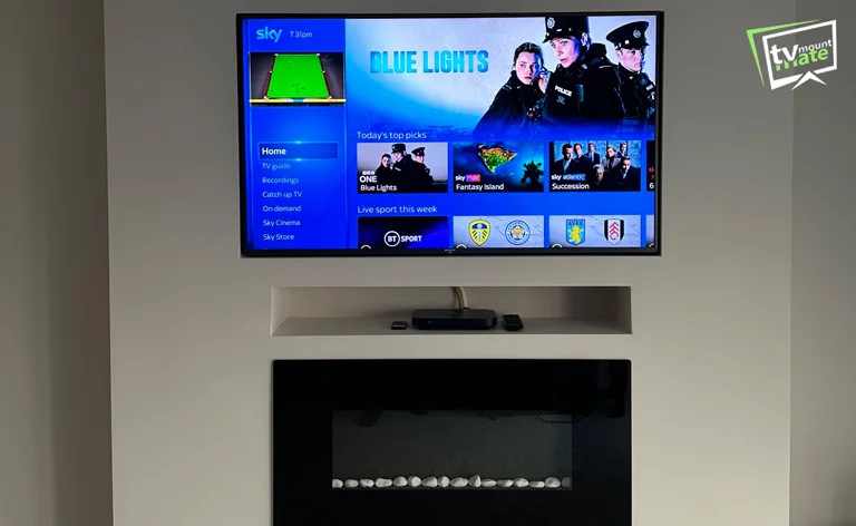 TV mounted on chimney breast above fireplace