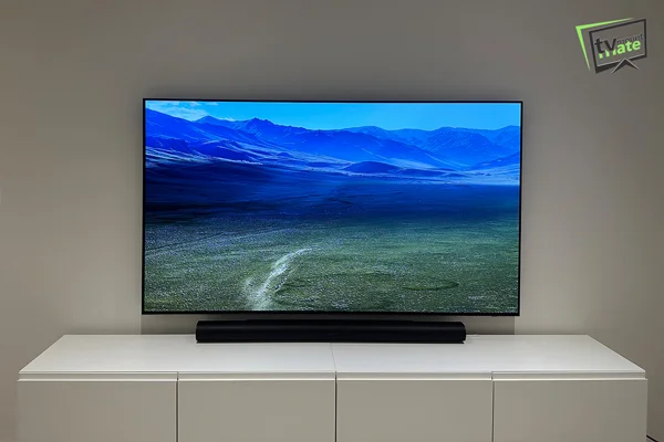 83 inch Samsung S95F TV mounted on a brick wall in Loughton with a Sonos soundbar below