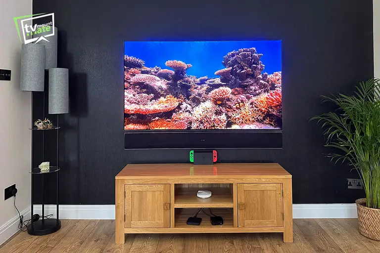 65-inch LG G5 OLED and LG soundbar mounted on a black brick feature wall in Northwood, Hillingdon.