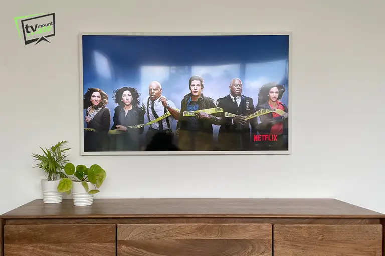 Front-facing view of a 65-inch Samsung Frame mounted on a dot-and-dab wall in Stockwell, London Borough of Lambeth. The original Slim Fit wall mount was secured using four GripIt plasterboard fixings, producing a clean gallery-style finish above the cabinet.