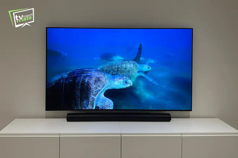 Front view of an 83-inch Samsung S95F OLED mounted above a white cabinet in Loughton